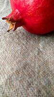 Red pomegranate fruit on canvas. Whole fruit and its grains. Square format. photo