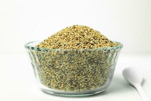 Sesame seeds in a glass bowl on a white background. photo