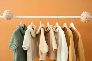 stylish baby clothes hanging on rack against color background. created generative ai. photo