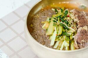 Yeolmunaengmyeon, korean style Buckwheat Noodles with YoungSummer Radish Kimchi, This dish features cold noodles in kimchi soup that is made by mixing salted young radish photo