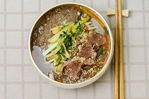Yeolmunaengmyeon, korean style Buckwheat Noodles with YoungSummer Radish Kimchi, This dish features cold noodles in kimchi soup that is made by mixing salted young radish photo