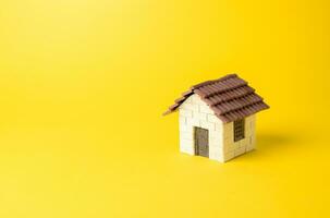 Residential house on a yellow background. Buying and selling housing. Property insurance. Design and architectural services. Real estate market review. Construction industry. photo