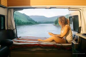 Camper girl relaxing inside camper van at riverside. photo