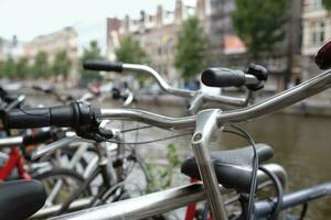 Row of bicycles in Amsterdam, Netherlands, next to the water photo