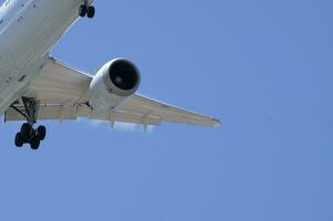 Detail of an approaching plane against a blue sky photo