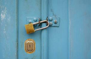 Turquoise wooden door with a padlock photo