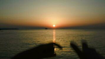 zonsondergang over- zee in hart gemaakt van handen video