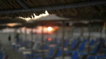 spiaggia con carrozza longue e cannuccia ombrelli a tramonto video