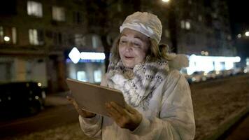 Mujer feliz viendo algo en la almohadilla durante la caminata nocturna video