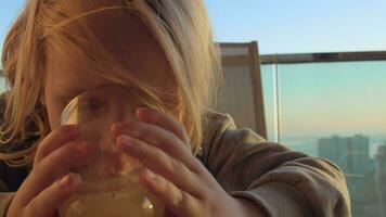 Child having juice for breakfast on the balcony video