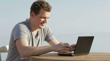 Man typing on a small laptop computer video