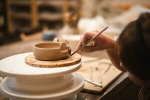 girl hands, pottery studio and painting cup in workshop for sculpture photo