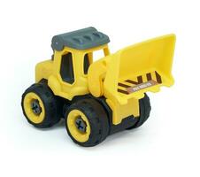 yellow plastic bulldozer toy isolated on white background. heavy construction vehicle toy. photo