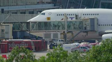 PHUKET, THAILAND NOVEMBER 27, 2019 - Passenger leaving Thai Airways Boeing 747 HS TGG trough the jet bridge. View from the top floor of the Splash Beach Resort hotel, Phuket, Thailand video