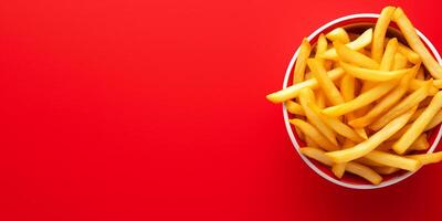 colorful minimalist bowl of crispy French fries top view layout isolated on red background, photo
