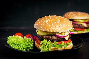 Big sandwich - hamburger burger with beef,  tomato, cheese, pickled cucumber and red onion. photo