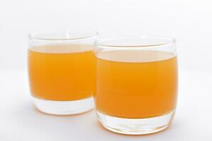 Glass glasses with orange juice on a white background. Delicious orange cooling drink. photo