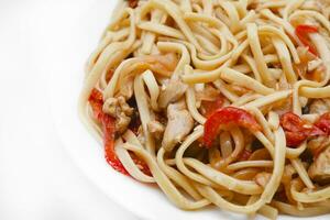 Korean Udon noodles with meat on a white plate. Delicious spicy meat breakfast. photo