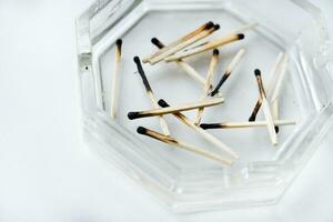 Burnt matches in a glass ashtray. Emotional burnout. photo