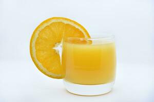 naranja jugo en un vaso vaso y el Fruta de naranjas refrescante bebida en un blanco antecedentes de fruta. foto