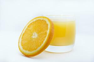 Orange juice in a glass glass and the fruit of oranges. Refreshing drink on a white background of fruit. photo