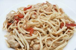 Korean Udon noodles with meat on a white plate. Delicious spicy meat breakfast. photo