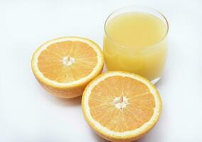 naranja jugo en un vaso vaso y el Fruta de naranjas refrescante bebida en un blanco antecedentes de fruta. foto