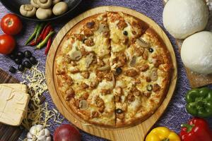 Flatbread pizza garnished with fresh angular on wooden pizza board top view dark stone background photo