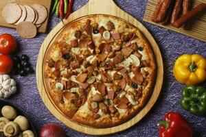 Flatbread pizza garnished with fresh angular on wooden pizza board top view dark stone background photo