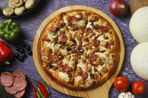 Flatbread pizza garnished with fresh angular on wooden pizza board top view dark stone background photo