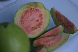 red guava slices isolated on white background. photo