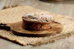 Round pastry with almonds and butter sprinkled with powdered sugar on the table, puff pastry photo