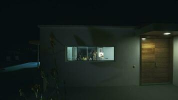 huis buiten visie met familie wezen gezien in de venster, avond schot video