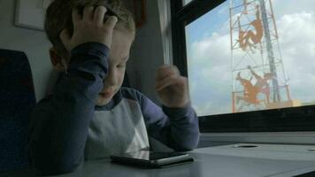 aburrido niño con con Teléfono móvil en Moviente tren video