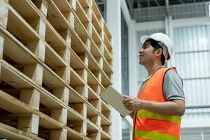 Asian male factory inspect pallet in warehouse or inventory and check stock product. Transport logistic business shipping, delivery to customers. inspection, storehouse, storage, factory photo