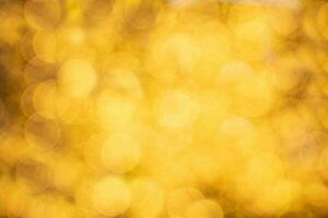 Yellow golden glow defocused abstract bokeh background. Christmas, New year, holiday, birthday, spring, summer, autumn, winter sunny wallpaper. Copy space photo