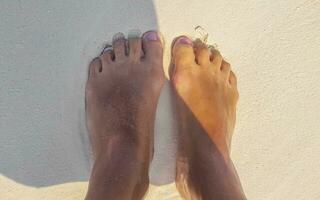 Sexy woman feet naked on the white beach sand Maldives. photo