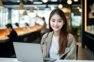 Portrait of Happy Asian Female Student Learning Online in Coffee Shop, Young Woman Studies with Laptop in Cafe, Doing Homework photo