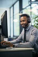 Portrait of a Handsome African Man, Customer Service Operator, Call Center Worker Talking Through Headset with Customer in Modern Office. photo
