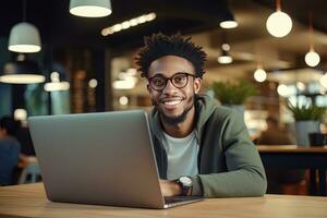 Portrait of Cheerful Black Male Student Learning Online in Coffee Shop, Young African American Man Studies with Laptop in Cafe, Doing Homework photo