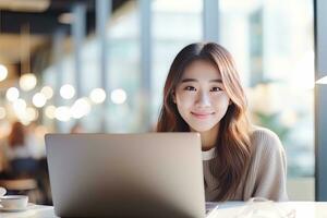 Portrait of Happy Asian Female Student Learning Online in Coffee Shop, Young Woman Studies with Laptop in Cafe, Doing Homework photo