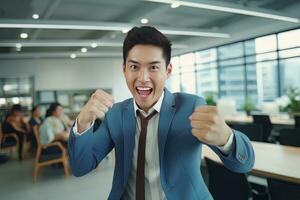 Asian Businessman Showing a Fighting Pose, Male Entrepreneur Gestures Raising Fists in Modern Office, Fights a Problem, Celebrate Success and Achieving Goals. photo