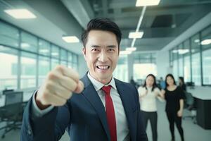 asiático empresario demostración un luchando pose, masculino empresario gestos levantamiento puños en moderno oficina, peleas un problema, celebrar éxito y lograr objetivos. foto