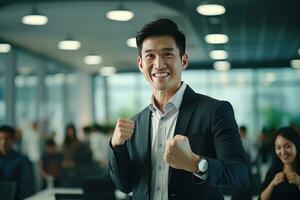 Asian Businessman Showing a Fighting Pose, Male Entrepreneur Gestures Raising Fists in Modern Office, Fights a Problem, Celebrate Success and Achieving Goals. photo