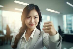 Asian Businesswoman Showing a Fighting Pose, Beautiful Manager Gestures Raising Fists in Modern Office, Female Entrepreneur Fights a Problem, Celebrate Success and Achieving Goals photo