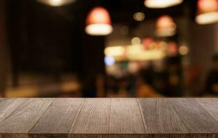 Mock up for space. Empty dark wooden table in front of abstract blurred bokeh background of restaurant . can be used for display or montage your product photo