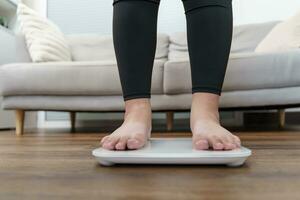 grasa dieta y escala pies en pie en electrónico escamas para peso control. medición instrumento en kilogramo para un dieta control. foto