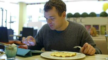 Man in cafe having dinner and using tablet PC video