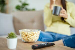 Asian woman Watching smart TV and using remote controller Hand holding television audio remote control at home with the remote control television photo