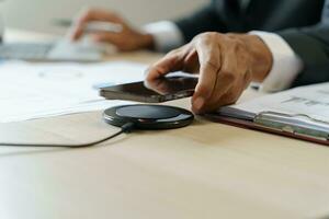 Charging mobile phone battery with wireless charging device in the table. Smartphone charging on a charging pad. Mobile phone near wireless charger Modern lifestyle technology concept photo